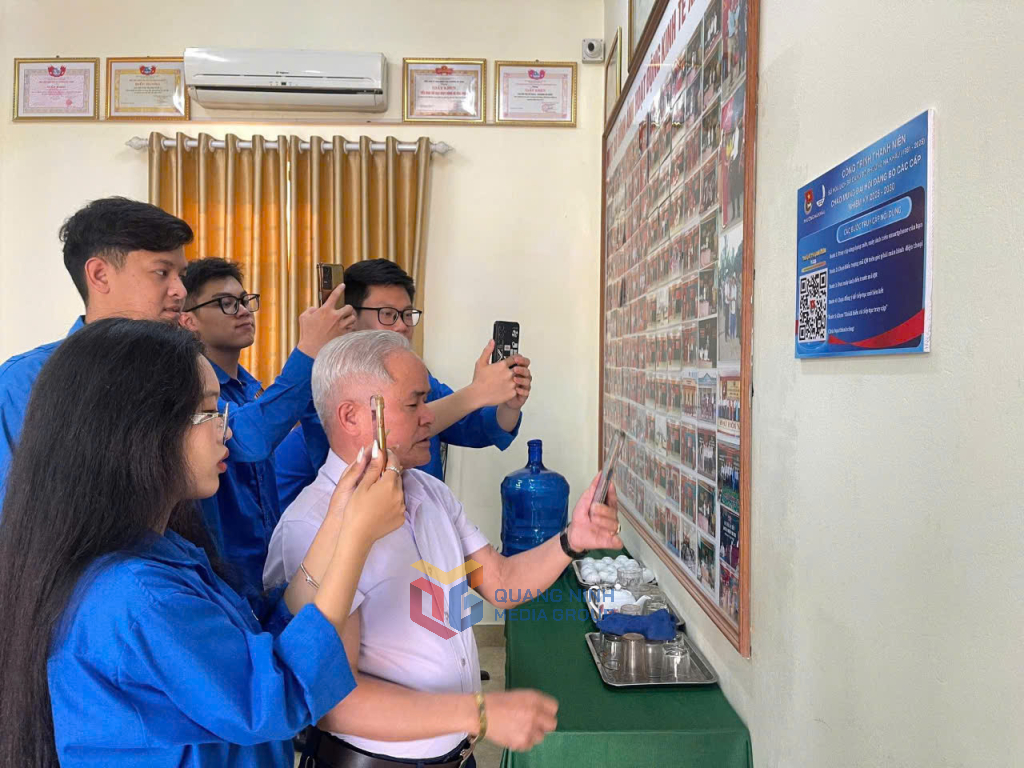 Người dân và thanh niên khu phố 4, phường Hà Khẩu quét mã QR để tìm hiểu thông tin về lịch sử hình thành và phát triển của Đảng bộ phường Hà Khẩu.