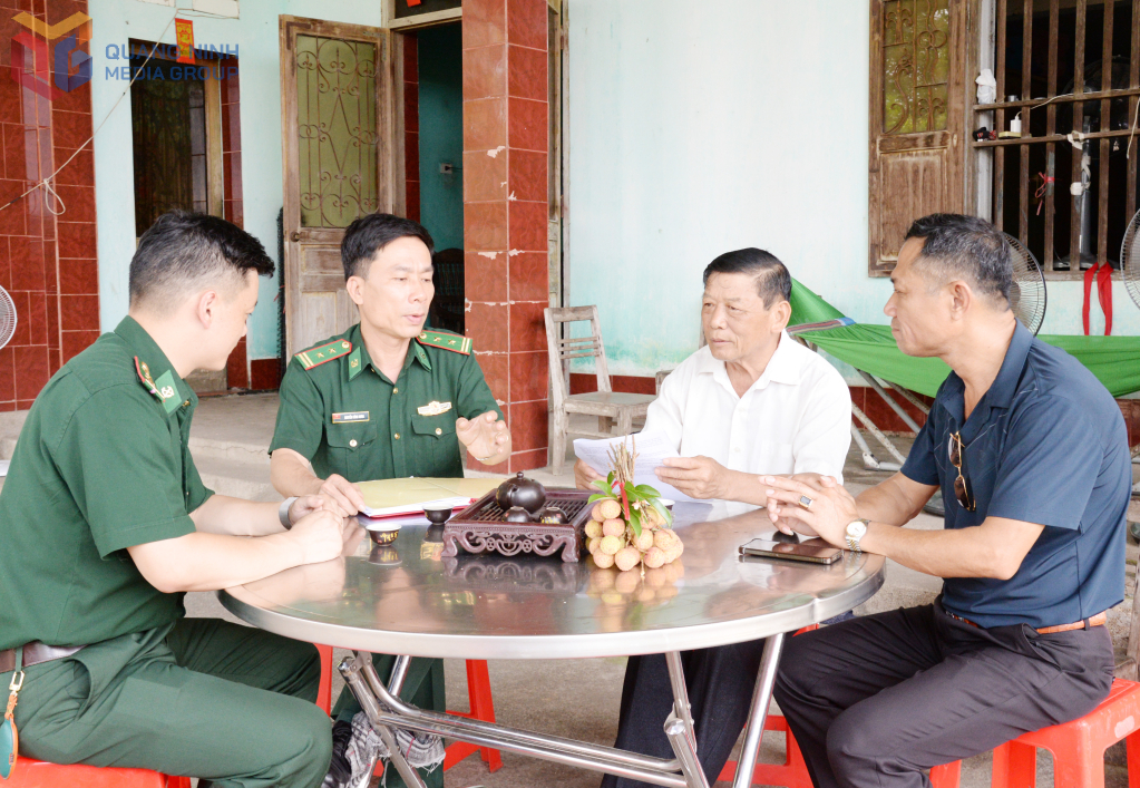 Ông Phòng Nhục Phí cùng cán bộ Đồn Biên phòng Quảng Đức trao đổi biện pháp vận động nhân dân tham gia bảo vệ chủ quyền, an ninh biên giới.