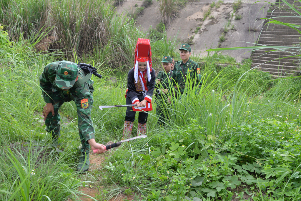 Cán bộ, chiến sĩ Đồn BPCK Hoành Mô cũng người dân xã Đồng Văn phát tuần tra, phát quang đường ra cột mốc biên giới.