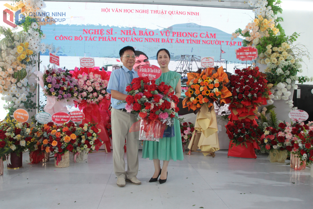 Lãnh đạo Sở Văn hoá, Thể thao và Du lịch tặng hoa chúc mừng tác giả.