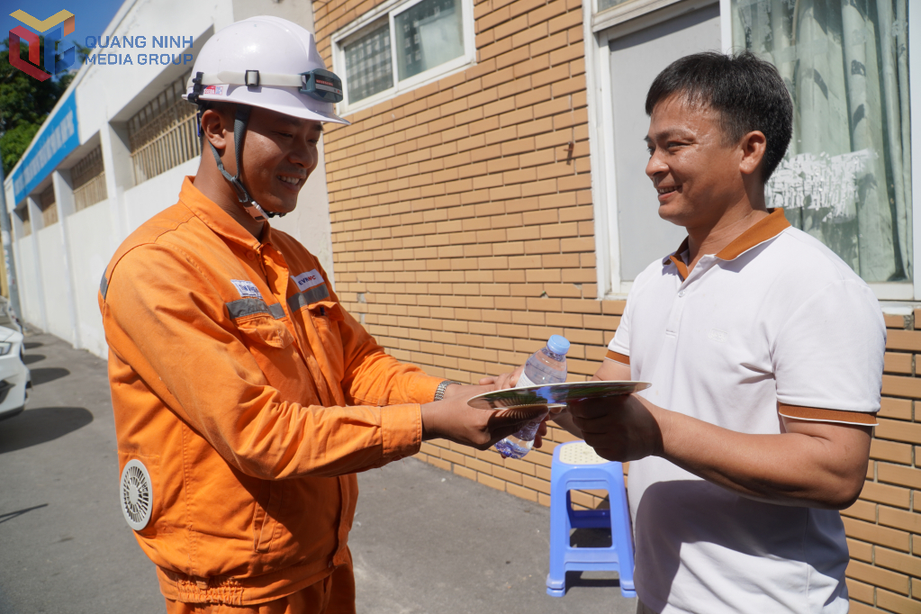 Cán bộ Công ty Điện lực Quảng Ninh phát nước miễn phí cho phụ huynh học sinh.