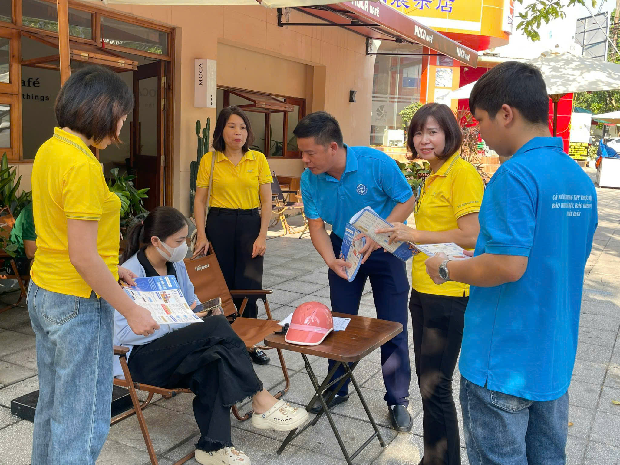 Cán bộ BHXH Thành phố phát tài liệu, giải đáp chính sách BHXH cho các tiểu thương tại các khu vực chợ trên địa bàn ( Ảnh Trung tâm TTVH TP Móng Cái)