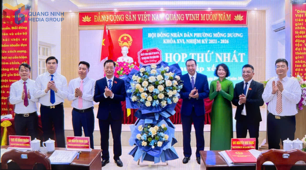 Lãnh đạo phường Mông Dương nhận hoa chúc mừng.