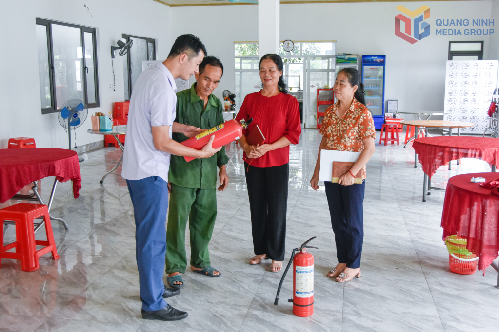 Các hộ dân ở xã Tiên Yên được tuyên truyền về trang bị, sử dụng bình chữa cháy tại gia đình. Ảnh: Hoàng Giang