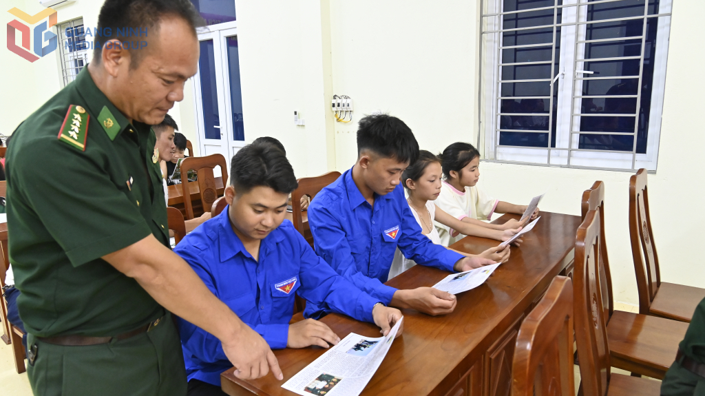 Cán bộ Biên phòng phát tờ rơi tuyên truyền cho nhân dân xã Hải Sơn.