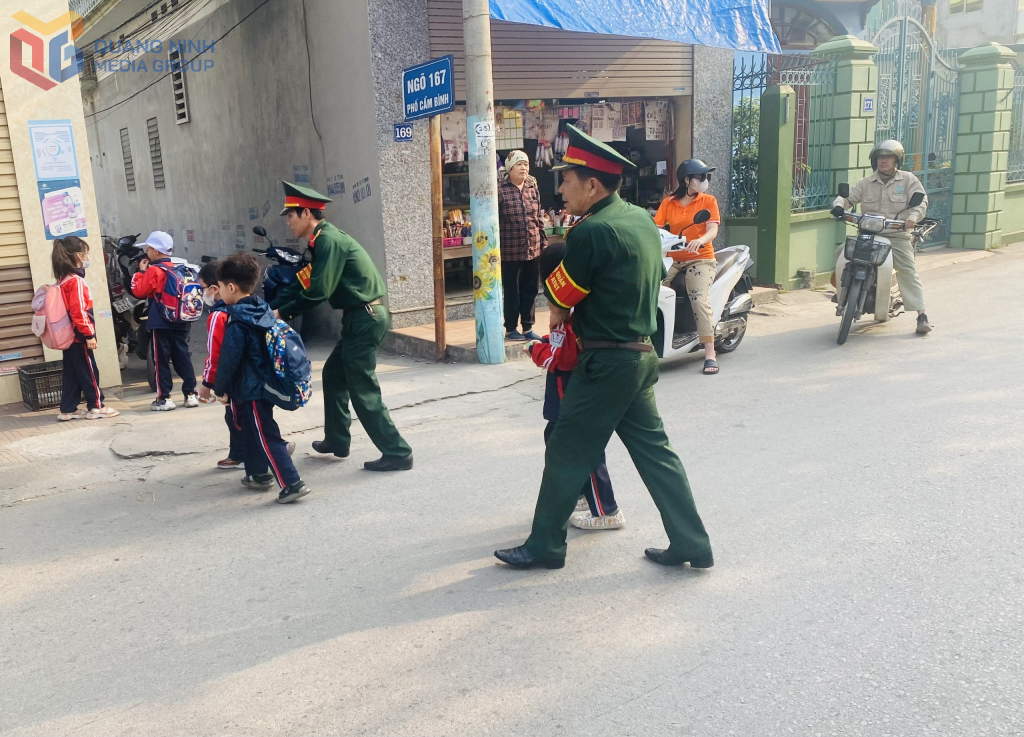 Hội CCB phường Quang Hanh hướng dẫn học sinh đi sang đường. Ảnh: Ngọc Trâm