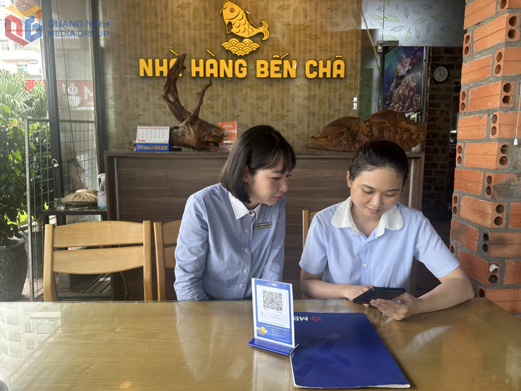 Nhân viên ngân hàng MB chi nhánh Quảng Ninh hỗ trợ hộ kinh doanh sử dụng ứng dụng m