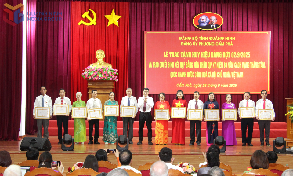 Đồng chí Hoàng Việt Dũng, Phó Bí thư Đảng ủy, Chủ tịch UBND phường Cẩm Phả, trao Huy hiệu Đảng cho các đồng chí 40 năm tuổi Đảng.