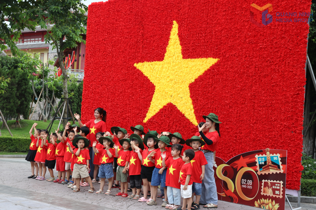 Các em nhỏ chụp hình lưu niệm với lá cờ tại Sun world Hạ Long.