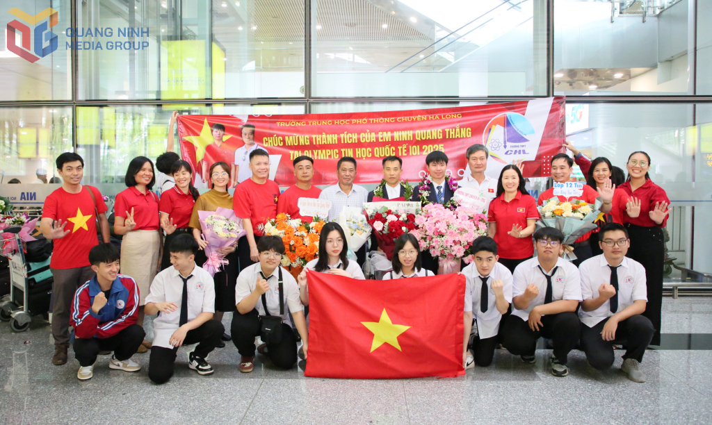 Các thầy cô và học sinh Trường THPT Chuyên Hạ Long chụp ảnh lưu niệm với Ninh Quang Thắng và thầy giáo Hà Đại Tôn trong ngày hai thầy trò trở về sau kỳ thi Tin học quốc tế tại Bolivia. Ảnh: Minh Hà