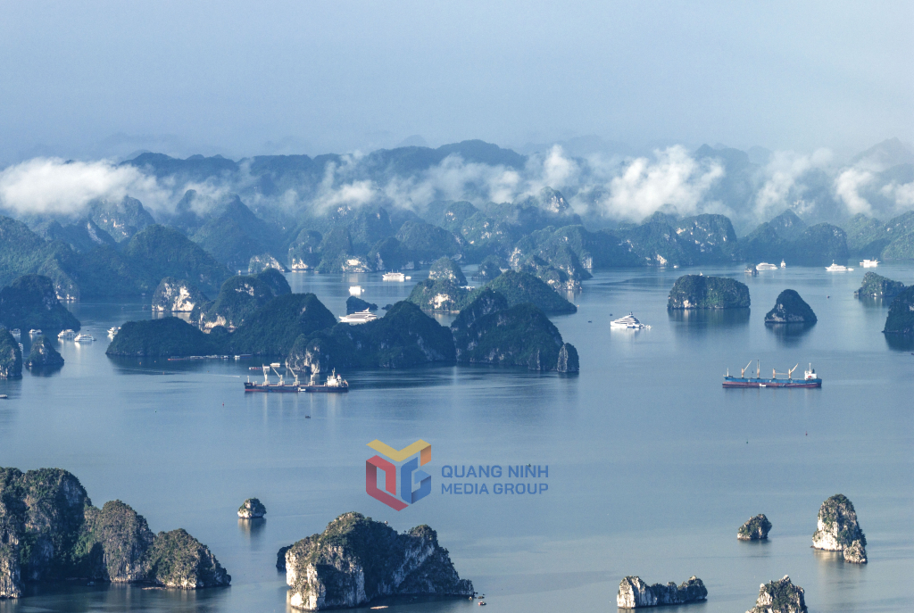 Núi đá và mây trời hòa quyện như những nốt nhạc nhẹ nhàng lướt trên mặt vịnh yên ả. 