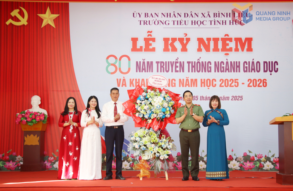 Thiếu tướng Trần Văn Phúc và đại diện các sở, ngành tặng hoa chúc mừng Nhà trường.