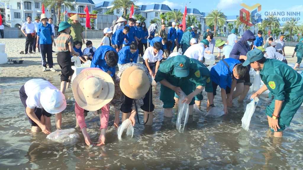 Đông đảo các đại biểu và nhân dân tham dự đã thả cá giống về vùng biển tự nhiên tại bãi tắm Bái Tử Long.