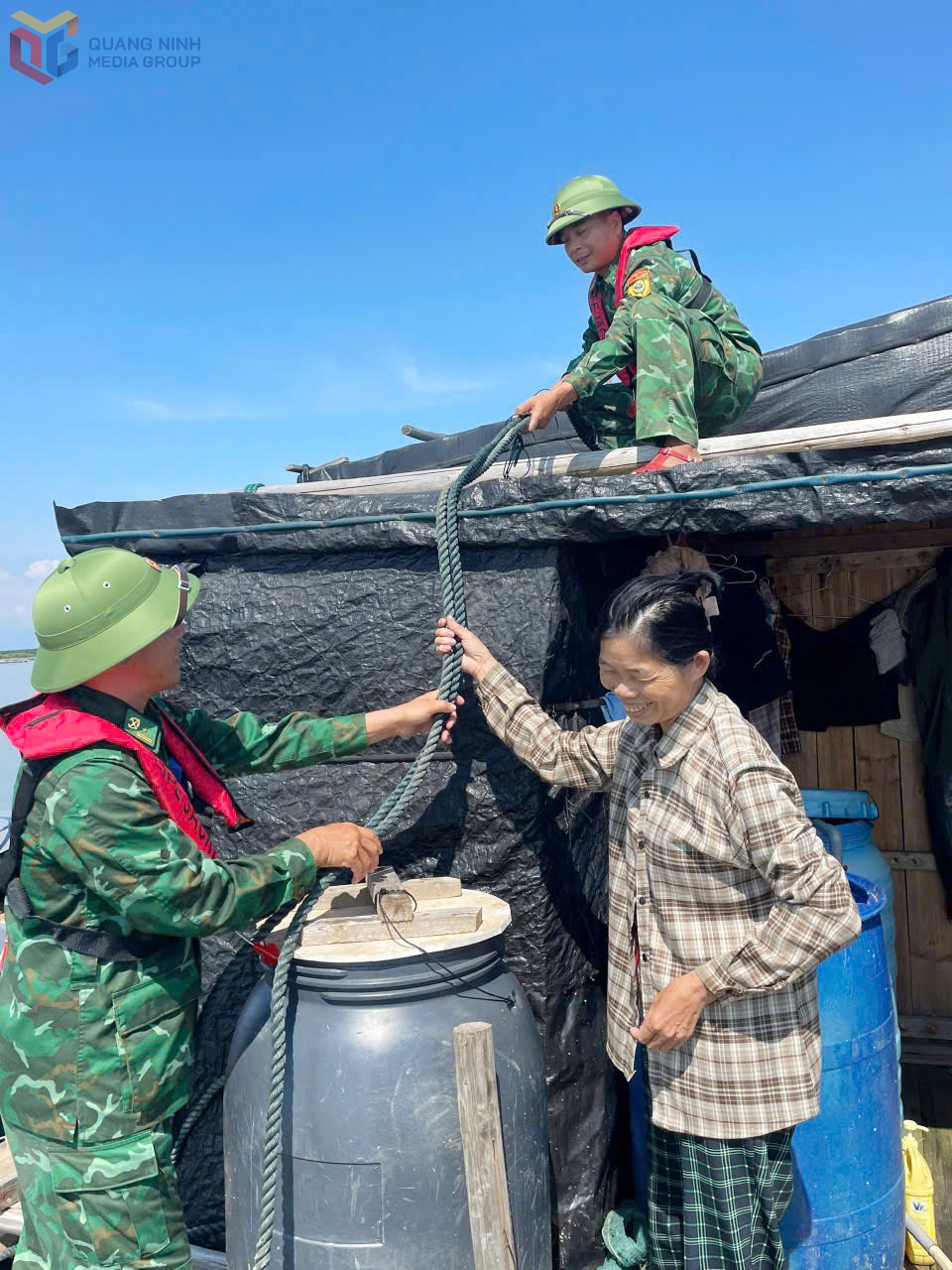 Lực lượng BĐBP hỗ trợ ngư dân chằng buộc, gia cố bè nuôi trồng thủy sản.