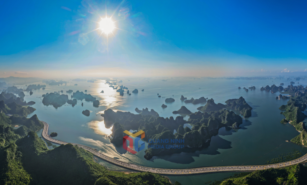Mặt trời lên trên mặt vịnh, phản chiếu dải đường uốn lượn mềm mại tựa bức tranh thủy mặc.