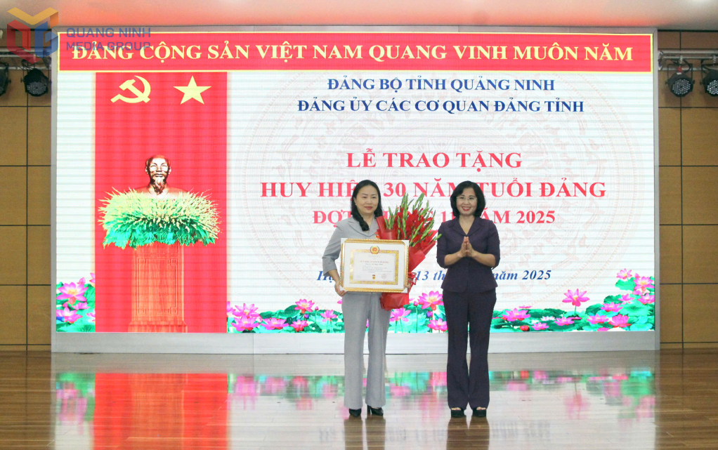 Đồng chí Trịnh Thị Minh Thanh, Phó Bí thư Thường trực Tỉnh ủy, Chủ tịch HĐND tỉnh, Bí thư Đảng ủy các cơ quan Đảng tỉnh trao huy hiệu 30 năm tuổi Đảng cho đồng chí Vi Ngọc Bích, Trưởng Ban Tổ chức Tỉnh ủy. 
