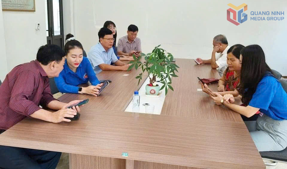 ĐVTN đặc khu Vân Đồn hướng dẫn người dân sử dụng các tiện ích số trên điện thoại thông minh. Ảnh: Dương Trường