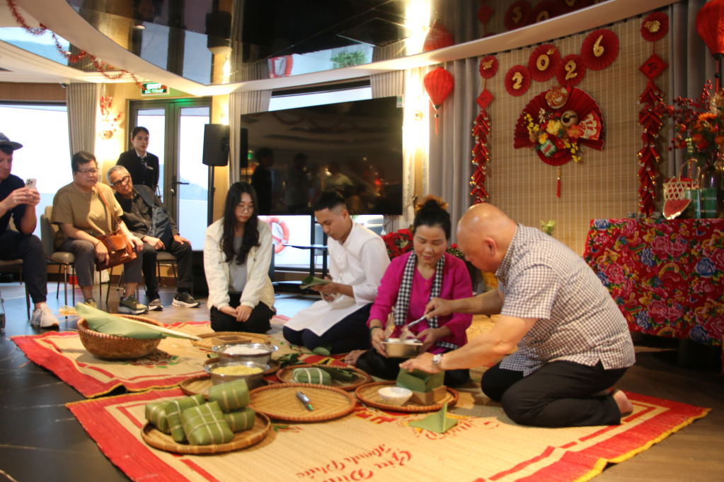 Du khách trải nghiệm gói bánh chưng trên du thuyền.