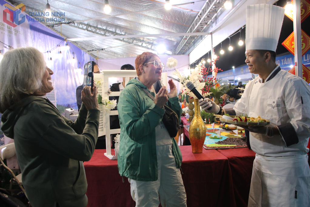 Du khách nước ngoài hào hứng trải nghiệm các món ăn hấp dẫn tại Liên hoan ẩm thực Quảng Ninh. 