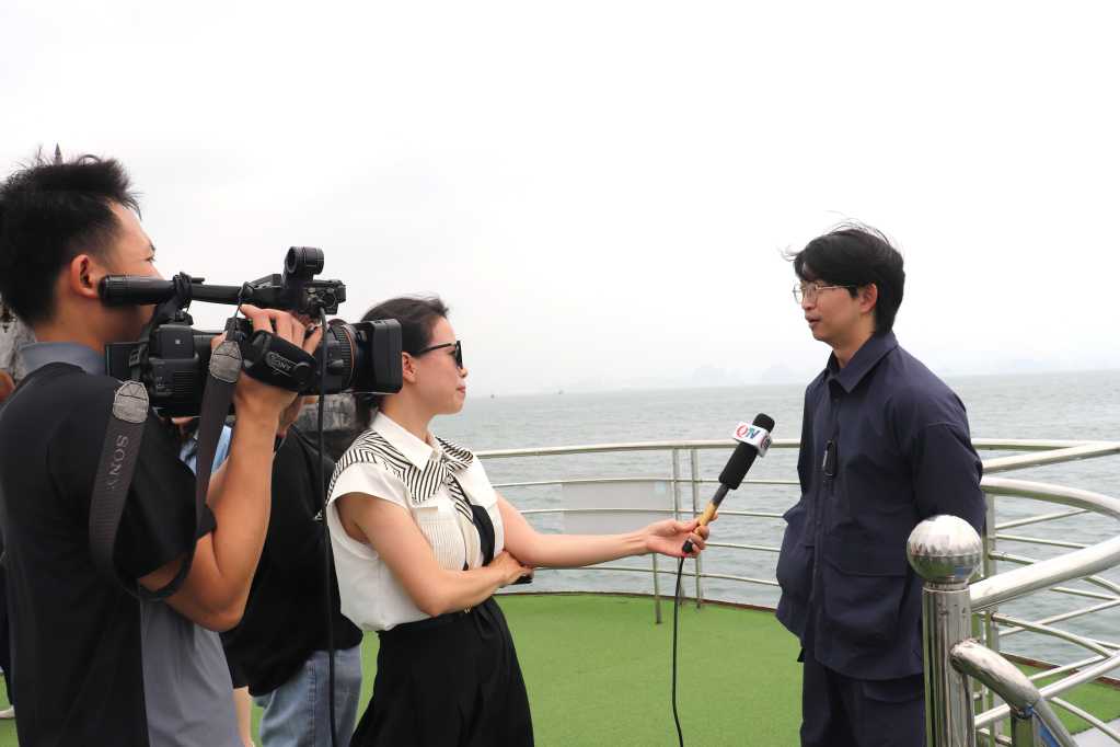 Phóng viên Báo và Phát thanh truyền hình Quảng Ninh tác nghiệp, ghi lại cảm nhận của chuyên gia truyền thông quốc tế khi thăm Vịnh Hạ Long. 