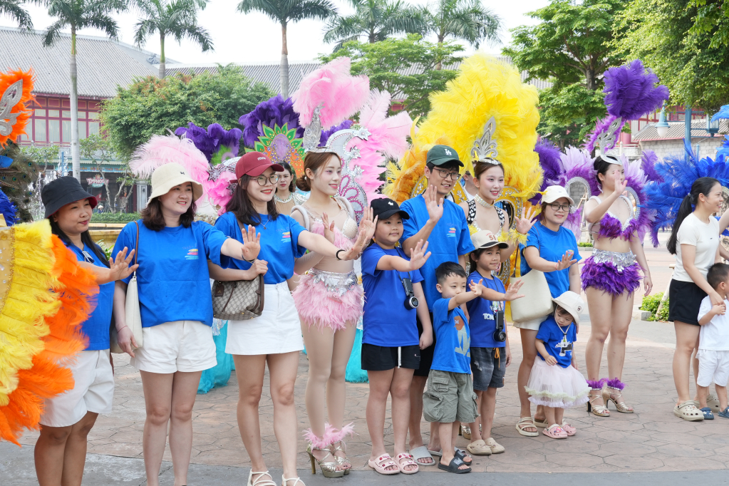 Du khách hào hứng chụp hình cùng các vũ công. 