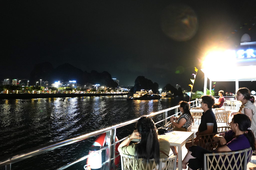 Du khách ngắm nhìn vẻ đẹp ven bờ Vịnh Hạ Long. 