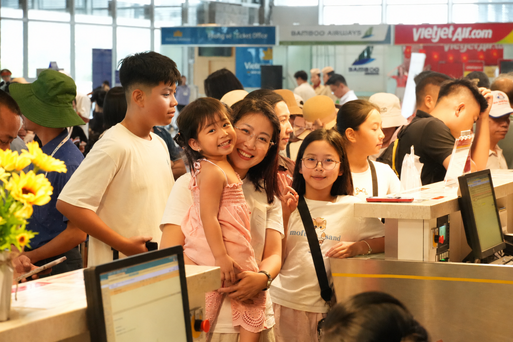 Các gia đình vui vẻ khi làm thủ tục trước khi lên máy bay đi TP Hồ Chí Minh.