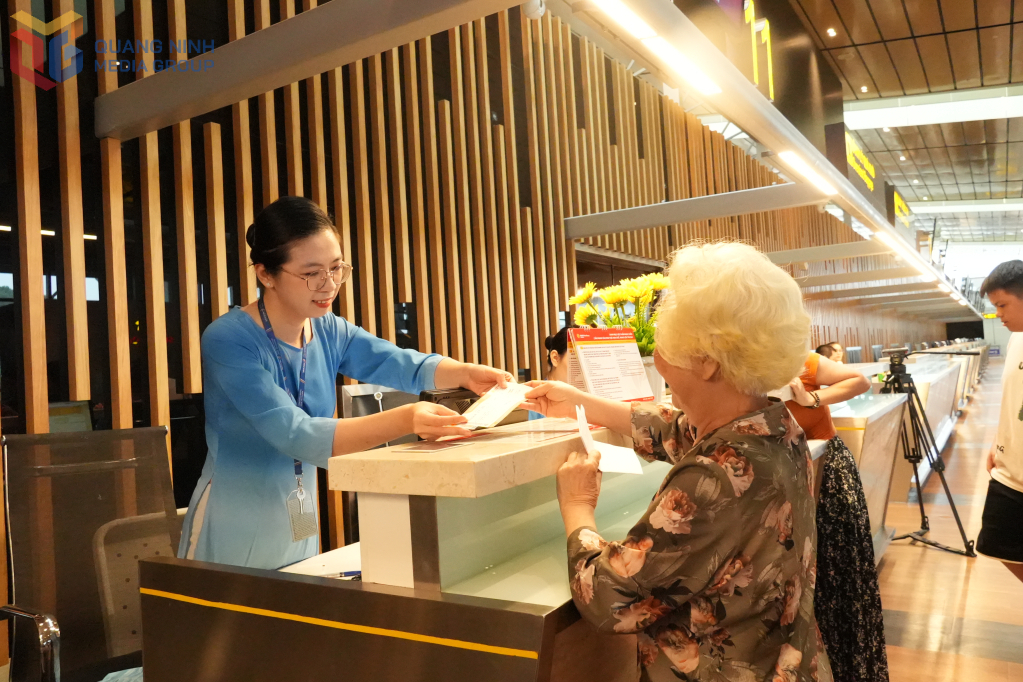 Nhân viên hỗ trợ hành khách làm thủ tục lên máy bay.
