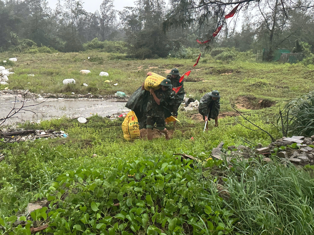 Lực lượng vũ trang trên địa bàn xã Vĩnh Thực ấy cát để giúp nhân dân gia cố những mái nhà yếu trong bão. Ảnh: Hữu Việt