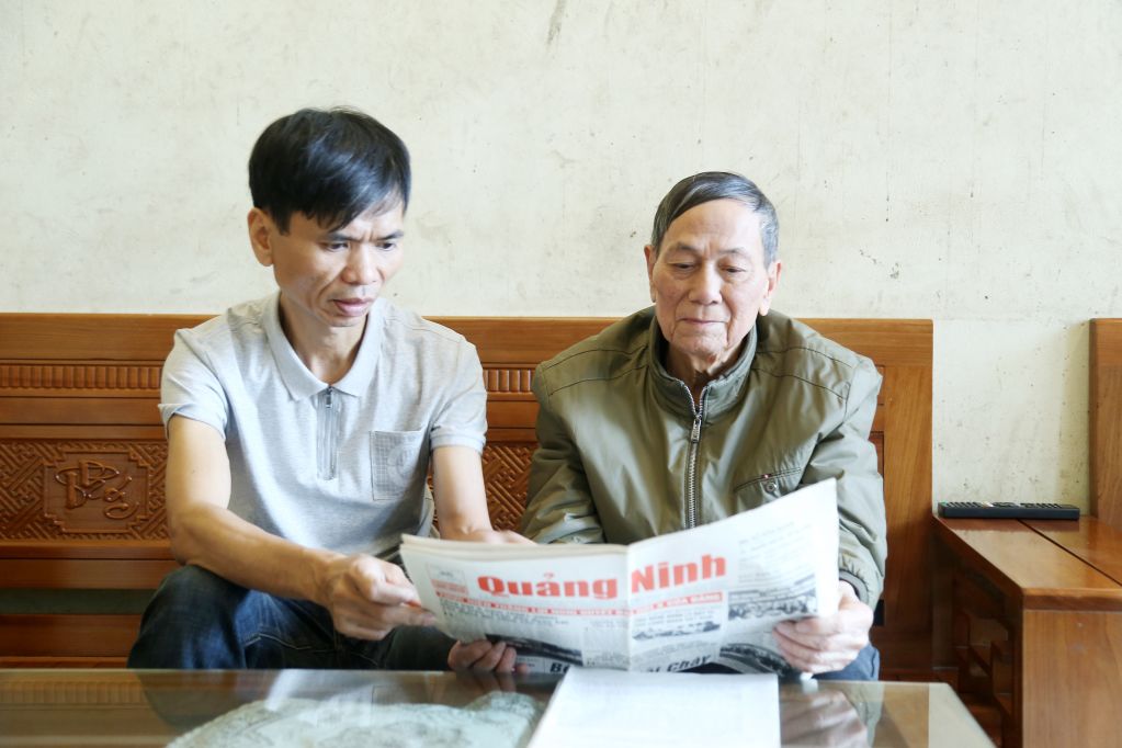 Cựu thuyền trưởng Trần Minh Chúc cùng con trai xem những tư liệu về Bến phà Bãi Cháy.