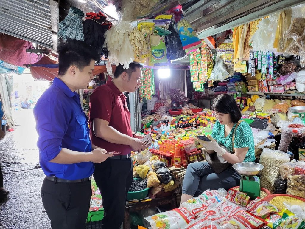 ĐVTN thị trấn Đầm Hà (huyện Đầm Hà) tuyên truyền thanh toán không dùng tiền mặt tại chợ Trung tâm huyện. Ảnh: Ngọc Trâm