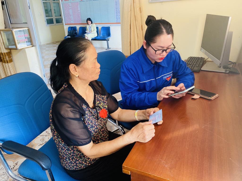 Đoàn viên thanh niên xã Tân Lập, huyện Đầm Hà hướng dẫn người dân nộp thủ tục hành chính quy dịch vụ công trực tuyến. Ảnh: Ngọc Trâm