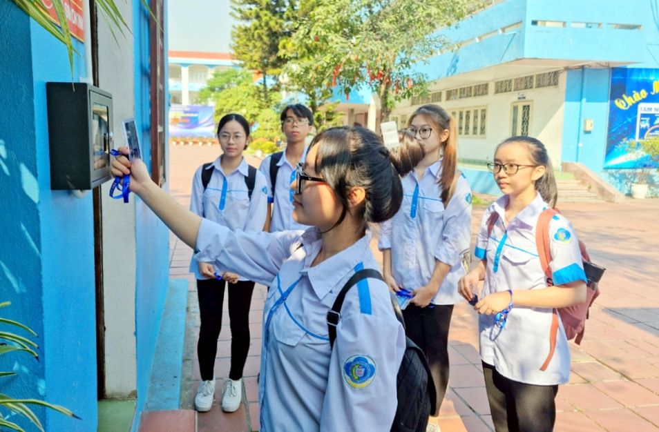 Học sinh Trường THPT Hoàng Quốc Việt (TX Đông Triều) thực hiện quét thẻ và nhận diện qua hệ thống điểm danh bằng thẻ từ. Ảnh: Song Hà