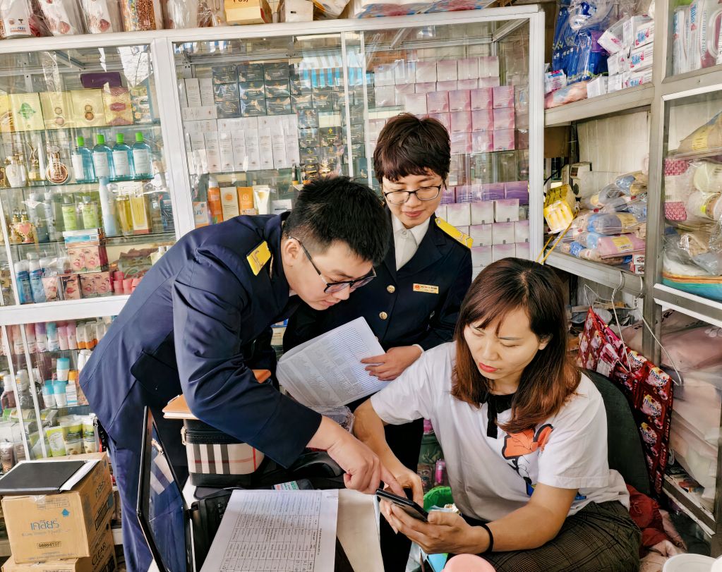 Đoàn thanh niên Cục Thuế tỉnh hướng dẫn người dân cài đặt ứng dụng Etax mobile. Ảnh: Vân Anh