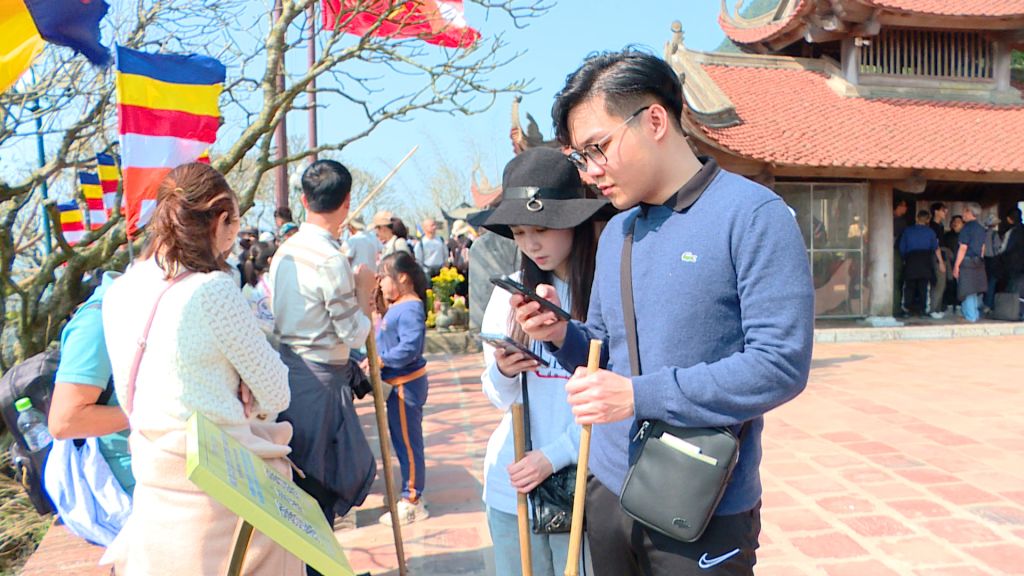 Khách du lịch quét mã QR để tìm hiểu về Khu di tích lịch sử và danh thắng