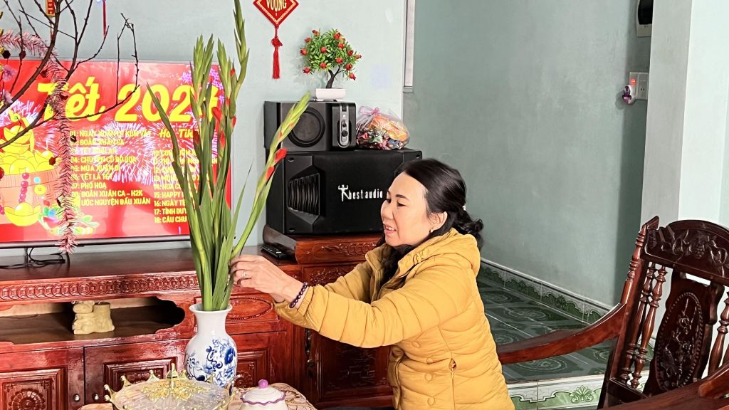 Chị Quế phấn khởi cắm những bông hoa dơn trong ngày Tết.