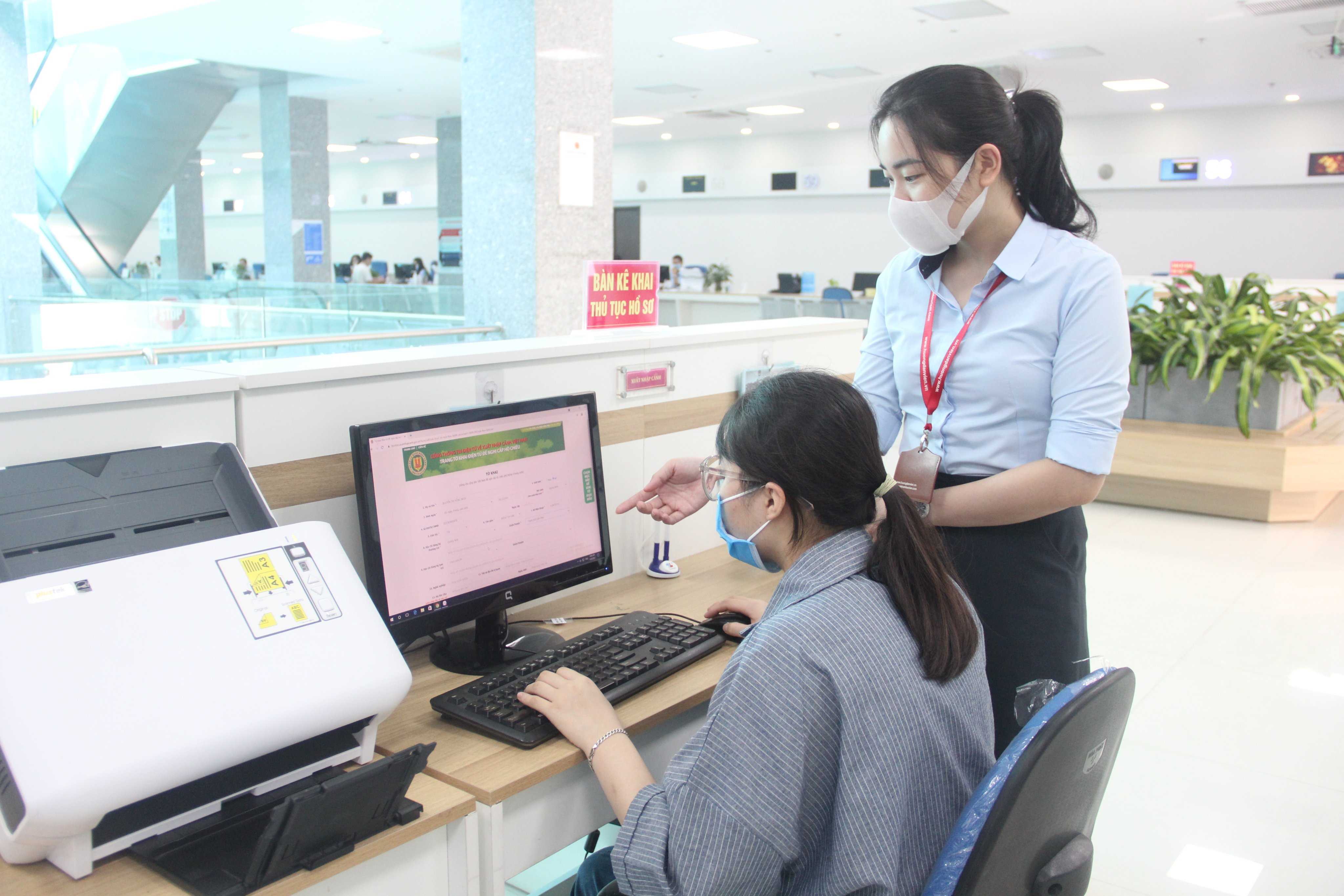 Cán bộ Trung tâm Phục vụ hành chính công tỉnh Quảng Ninh hướng dẫn người dân nộp hồ sơ qua mạng.